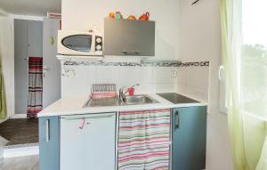 a small kitchen with a sink and a microwave at Nice Home In Le Minihic-Sur-Rance in Le Minihic-sur-Rance