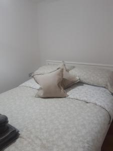 ein weißes Bett mit zwei Kissen darauf in der Unterkunft Jasmine Cottage in Shrewsbury