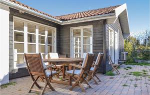 a patio with a wooden table and chairs at Holiday Home Hornbæk With Hot Tub Ix in Hornbæk