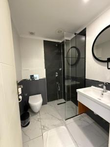 a bathroom with a shower and a toilet and a sink at Red Castle Hotel & Pub in Belek +26 photos