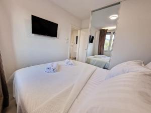 a white bedroom with two beds and a mirror at MonLux studio- FREE Public Parking-Easy Walk to the Center in Split