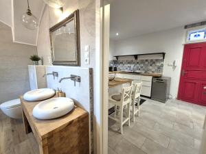 a bathroom with two sinks and a kitchen with a red door at Apartment Zoe - Old Town in Bratislava +28 photos