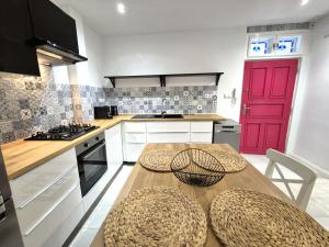 a kitchen with a wooden table and a red door at Apartment Zoe - Old Town in Bratislava