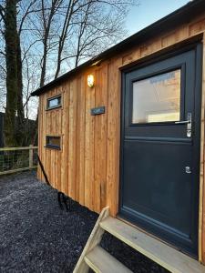 梅奈布里奇Cybi, Modern Shepherds Hut with Games Room Access的小木屋设有门和窗户
