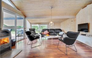 a living room with black leather chairs and a fireplace at Lovely Home In Saltum With Kitchen in Saltum
