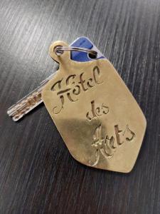 a brass tag with writing on it on a table at Hôtel des ARTS Aix in Aix-en-Provence