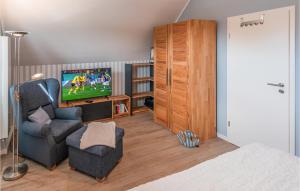 sala de estar con TV y silla en Cozy Home In Büsum With Wifi, en Büsum