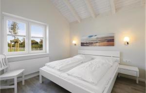 a white bedroom with a bed and two windows at Beautiful Home In Dagebüll With Sauna in Dagebüll