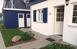 a white house with blue doors and a yard at Ferienhaus 34 Altefähr in Altefähr