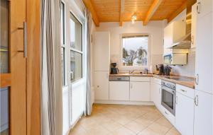 a kitchen with white cabinets and a window at Seebrise in Süssau