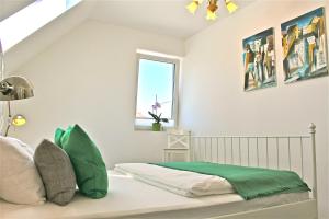 una camera da letto con letto con lenzuola verdi e finestra di ferien-wohnen a Mautern an der Donau