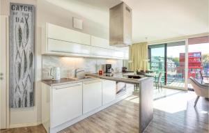 eine Küche mit weißen Schränken und einem großen Fenster in der Unterkunft Passatvilla - Apartment 5 in Travemünde