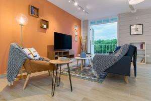Una sala de estar con dos sillas y un televisor. en Casa La Costa By Wynwood House, en Panamá