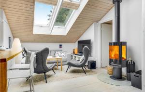a living room with a fireplace and chairs at Two-Bedroom Holiday Home With A Fireplace In Sjællands Odde in Yderby