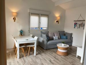 ein Wohnzimmer mit Sofa und Tisch in der Unterkunft Appartement Côté Bassin in Andernos-les-Bains