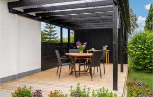 a wooden deck with a table and chairs on it at Stunning Home In Bogense With Wifi in Bogense +13 photos