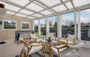a conservatory with a table and chairs and windows at Gorgeous Home In Hejls With Wifi in Hejls
