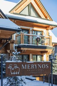 a sign in front of a log house at Aparthotel Merynos in Zakopane