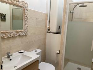ein Badezimmer mit Waschbecken, Toilette und Spiegel in der Unterkunft Appartement Côté Bassin in Andernos-les-Bains