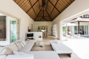 a living room with white couches and a television at New Moon in Ubud