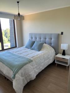 a bedroom with a large bed with a large window at Costanera playa in Villarrica +13 photos