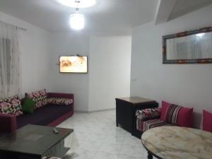 a living room with a couch and a table at APPARTEMENT AL HOCEIMA prés de PLAGE CALABONITA in Al Hoceïma