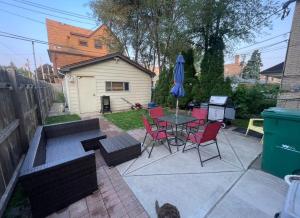 a patio with a table and chairs and a table and a cat at Chi-Town Ultimate Hideout 1-2-3 in Berwyn