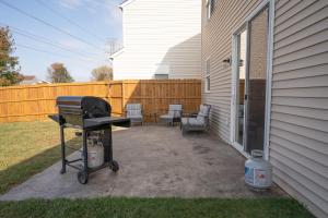 a barbecue grill on a patio next to a house at 12MINSTOLOUVILLE,GAMERM,PATIOGrill-RusticElephant in Jeffersonville