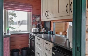eine Küche mit weißen Schränken und einem Herd mit Backofen in der Unterkunft Holiday Home Vatnestr in Mykland
