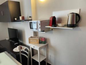 a room with a kitchen with a desk with a microwave at Cav Pop Sky in Seregno