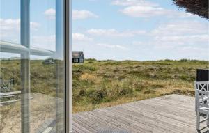 a glass door leading to a deck with a view of a house at 3 Bedroom Gorgeous Home In Blåvand in Blåvand +17 photos