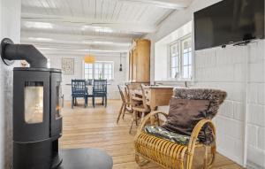 a living room with a wood stove and a dining room at 3 Bedroom Gorgeous Home In Blåvand in Blåvand