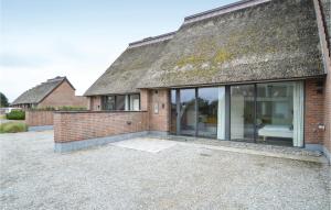 an extension to a brick house with large windows at Two-Bedroom Holiday Home In Romo in Sønderby