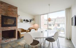 a dining room with a white table and chairs and a fireplace at Two-Bedroom Holiday Home In Romo in Sønderby