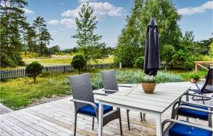 a patio with a white table and chairs and an umbrella at Cozy Home In Yngsjö With Kitchen in Yngsjö