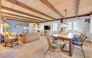 a dining room and living room with a table and chairs at Holiday Home Rauhesvej Hvide Sande in Bjerregård
