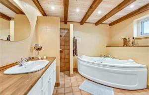 a bathroom with a large tub and a sink at Holiday Home Rauhesvej Hvide Sande in Bjerregård