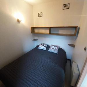 a small bedroom with a black bed with two pillows at Résidence Relais - Agréable T2 bien équipé de 6 couchages avec vue sur les pistes 238R MAE-5481 in Réallon
