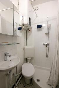 a white bathroom with a toilet and a sink at Studio Maurepas centre-ville in Maurepas