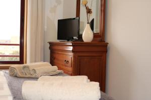 a room with a tv and a dresser with towels at Apartamento Galerias in Porto