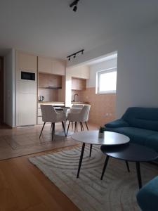 クープレスにあるApartman Mikaの青いソファとテーブルのあるリビングルーム