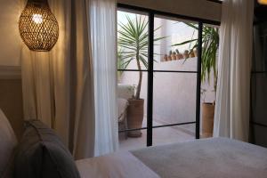 a bedroom with a bed and a large glass door at Riad Solange in Marrakesh