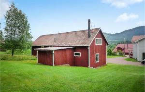 a red barn sitting in a field of green grass at Amazing Apartment In Älvdalen in Älvdalen