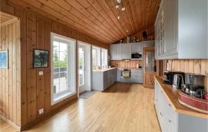 a large kitchen with wooden walls and wooden floors at Beautiful Home In Sjusjøen With Sauna in Sjusjøen
