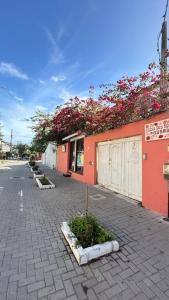 an empty street with flowers on the side of a building at Pousada Casa das Rosas in Búzios