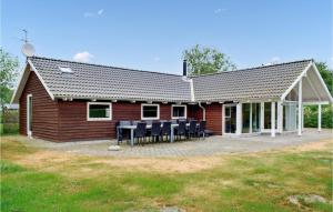 a house with tables and chairs in front of it at Holiday Home Vestensøvej Ebeltoft Xii in Ebeltoft