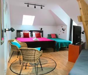 a bedroom with two beds and a table and chairs at Pavillon Hugo - Maison Etape in Nemours