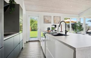 Una cocina con gabinetes blancos y un fregadero. en Cozy Home In Samsø With Kitchen, en Onsbjerg