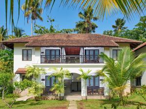 una casa con balcone e palme di Club Mahindra Cherai Beach a Cherai Beach