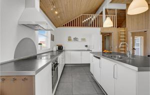a kitchen with white cabinets and a wooden ceiling at Nice Home In Sydals With Sauna in Høruphav